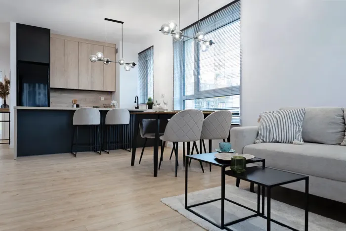 Modern condo kitchen renovation with sleek black and wood cabinetry, LED accent lighting, and contemporary dining area in Toronto