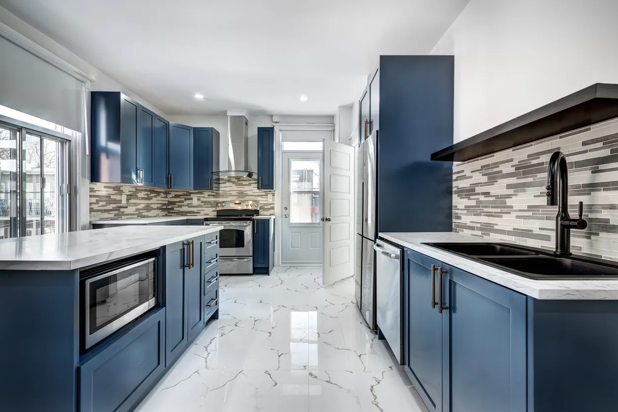 Custom kitchen cabinets with blue shaker doors and marble countertops in Toronto by Leo Constra