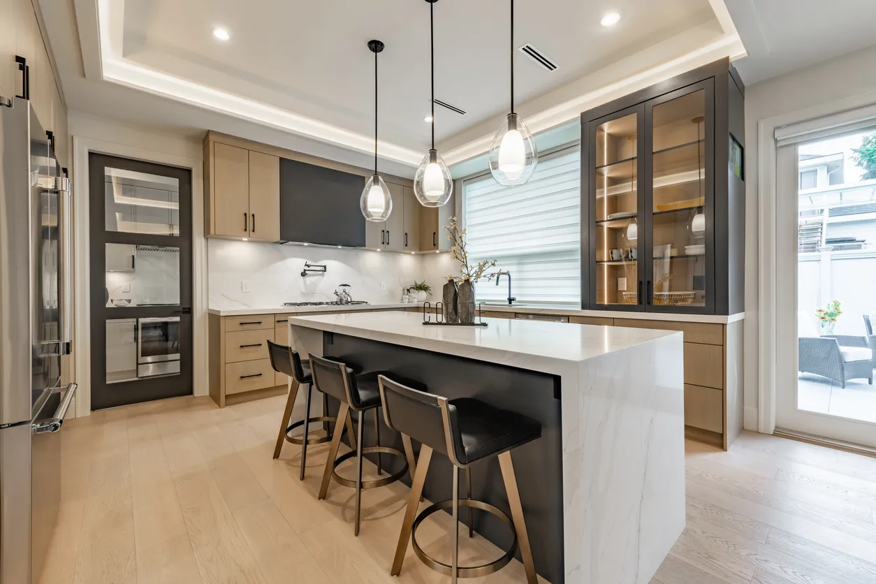 White island with quartz countertops and wood accents in Ontario kitchen